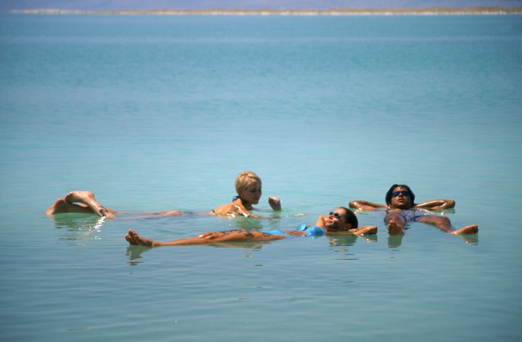 Three woman float atop the highly saline water of the Dead Sea in Jordan.