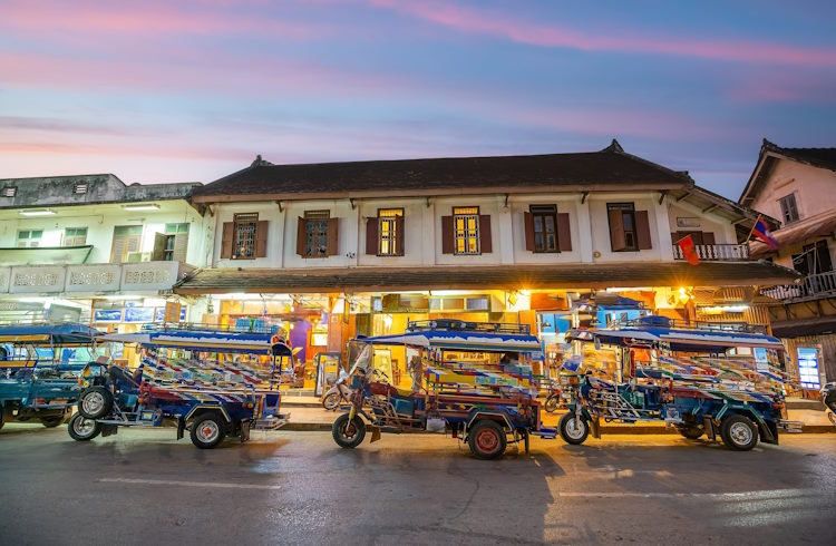Loatian tuk-tuks lined up outside a building in Luang Prabang, Laos.