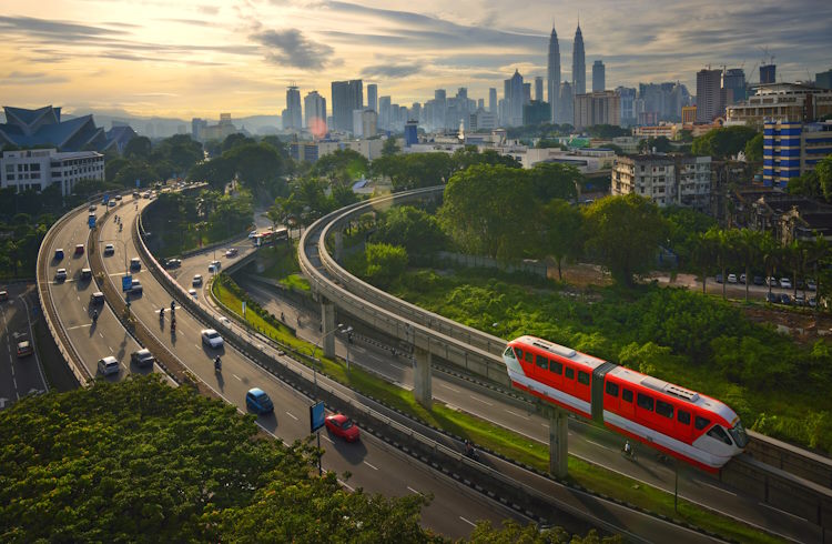 A light-rail train on an elevated track outside Kuala Lumpur, Malaysia.