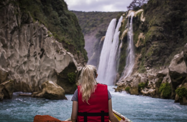 A woman sits in a canoe near Tamul Waterfall, Huasteca Potosina, Mexico.