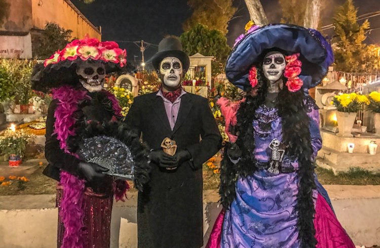 Dia de los Muertos festival-goers dressed in elaborate costumes.