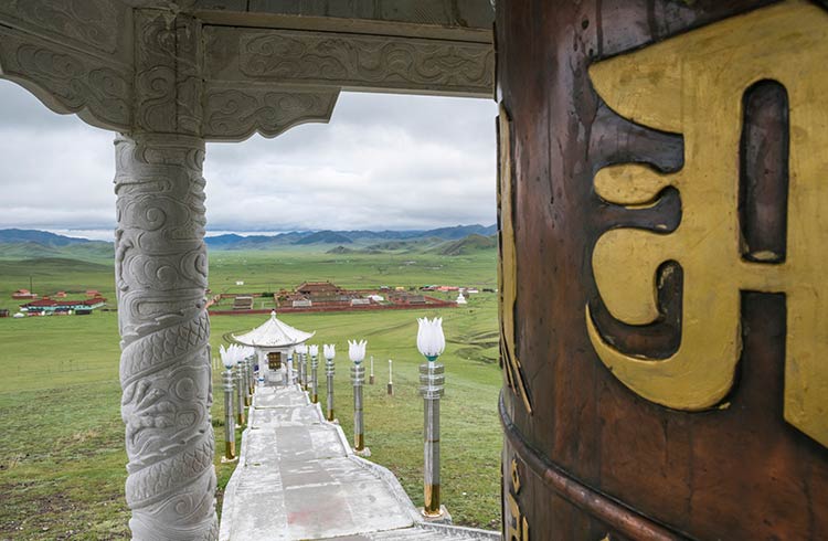 Prayer wheel at the ovoo with Amarbayasgalant Monastery in the background