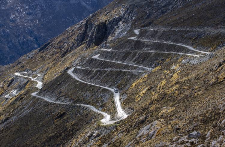 A bus drives down a road filled with hairpin turns in the Cordillera Blanca region of Peru.