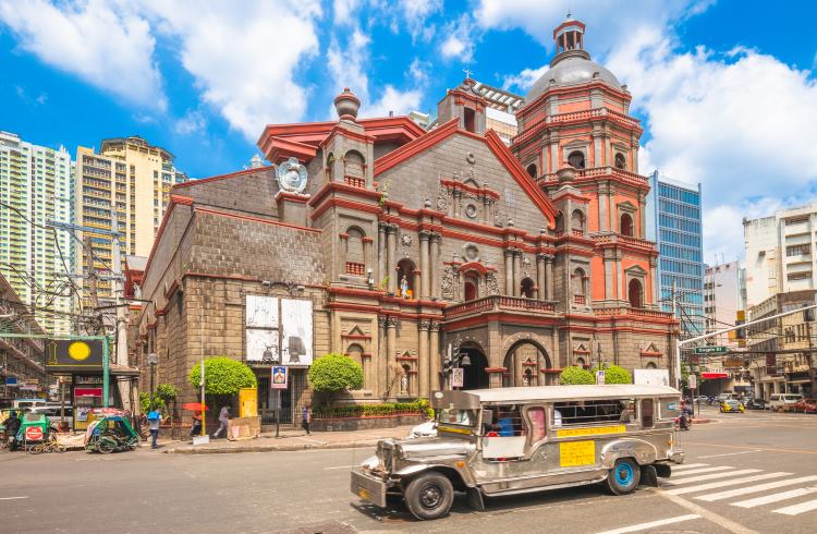 A jeepney bus drives past the Minor Basilica of Saint Lorenzo Ruiz in Manila.