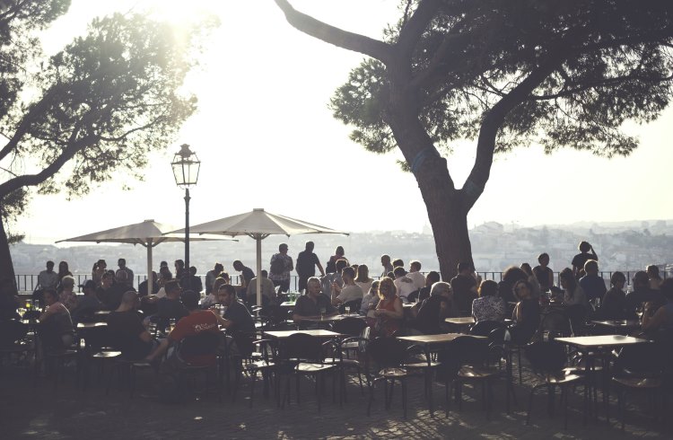 People sit enjoying the view on a terrace in Graca, Lisbon.