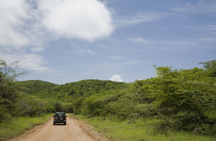 An SUV drives down a dirt road on the island of Vieques, Puerto Rico.
