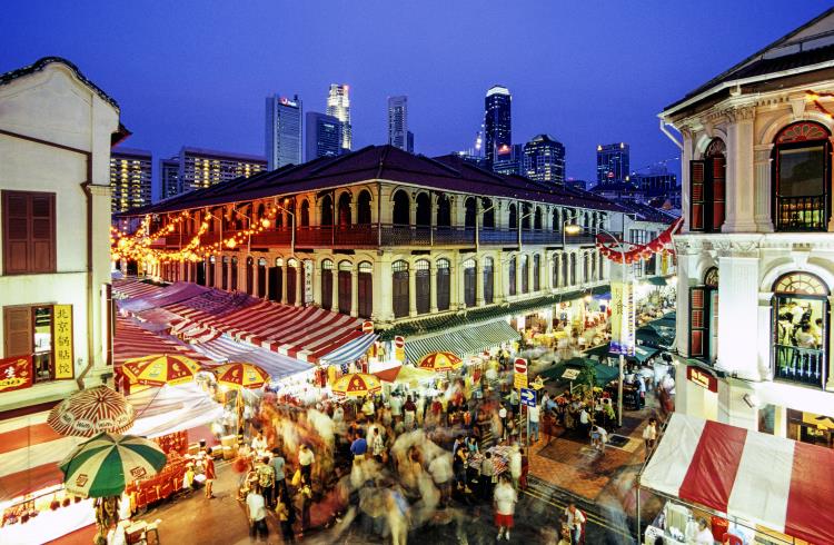 Crowds walk through the food market in Singapore's Chinatown.