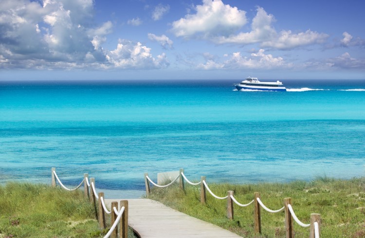 A ferry boat sails past the coast of Formentera, Spain.