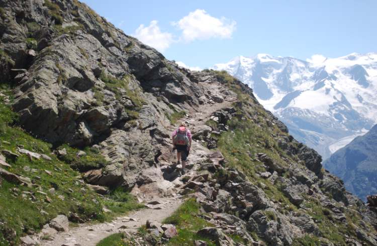 A hiker climbs an alpine trail above St. Moritz in eastern Switzerland.