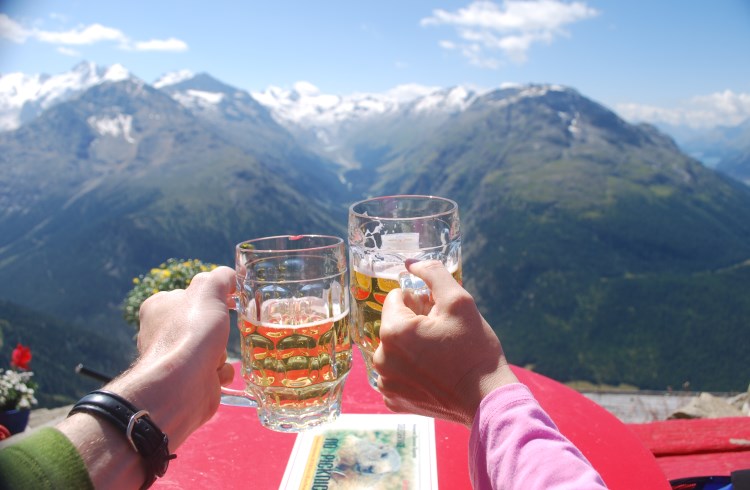 Hikers enjoy a beer at the Segantini Hut while gazing up the Val Roseg near St. Moritz, Switzerland..