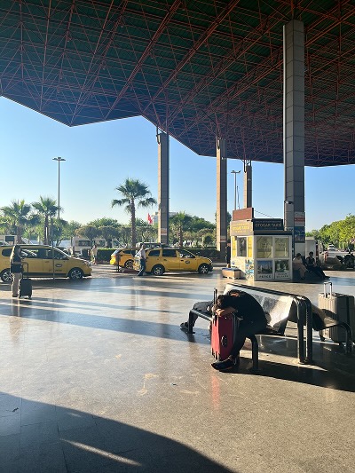 A person resting on a bench at a bus depot in Turkey