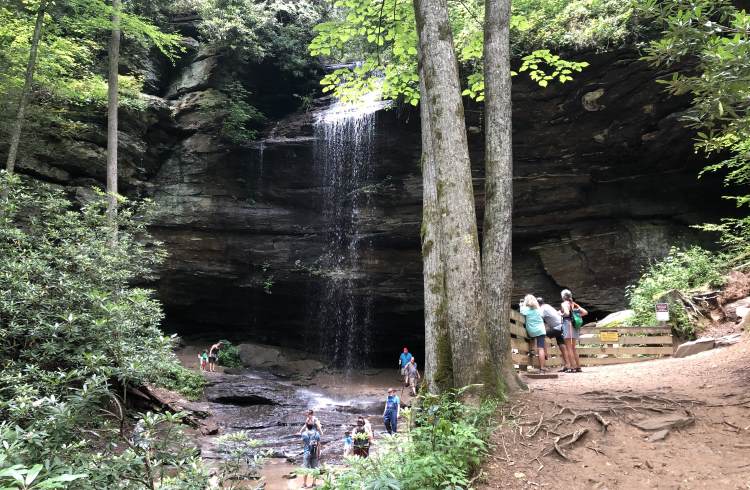Hikers gather at the foot of Moore Cove Falls in Pisgah National Forest, Transylvania County, North Carolina.