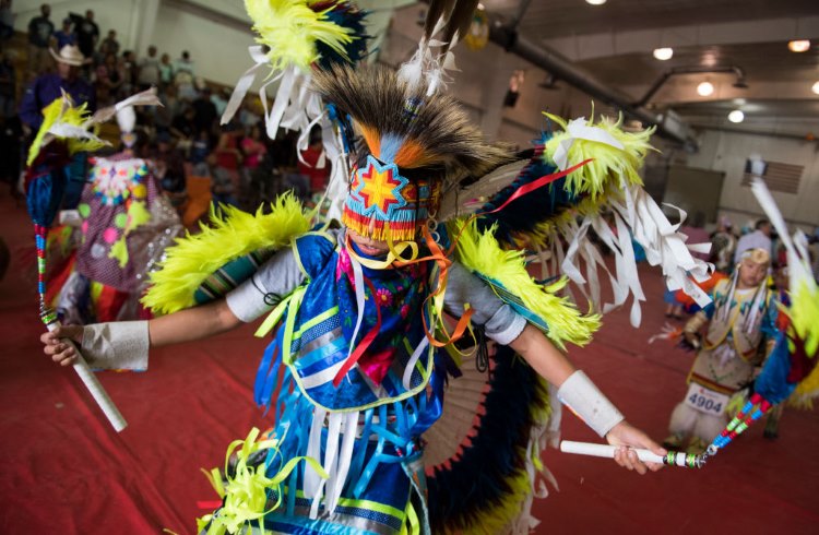 A colorfully costumed tribal member performs a traditional dance at Crow Fair in Montana.