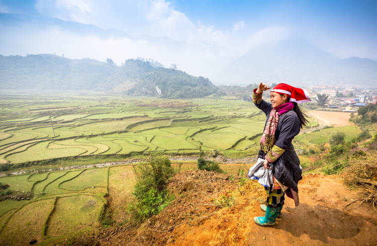 A member of the Red Dao hilltribe overlooks terraced fields near Sapa, Vietnam.