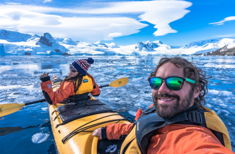 Professional content creators NOMADasaurus taking a selfie on a kayak in Antarctica.