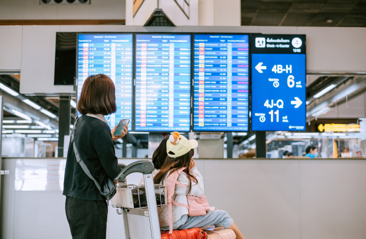 family checking boarding time at digital timetable