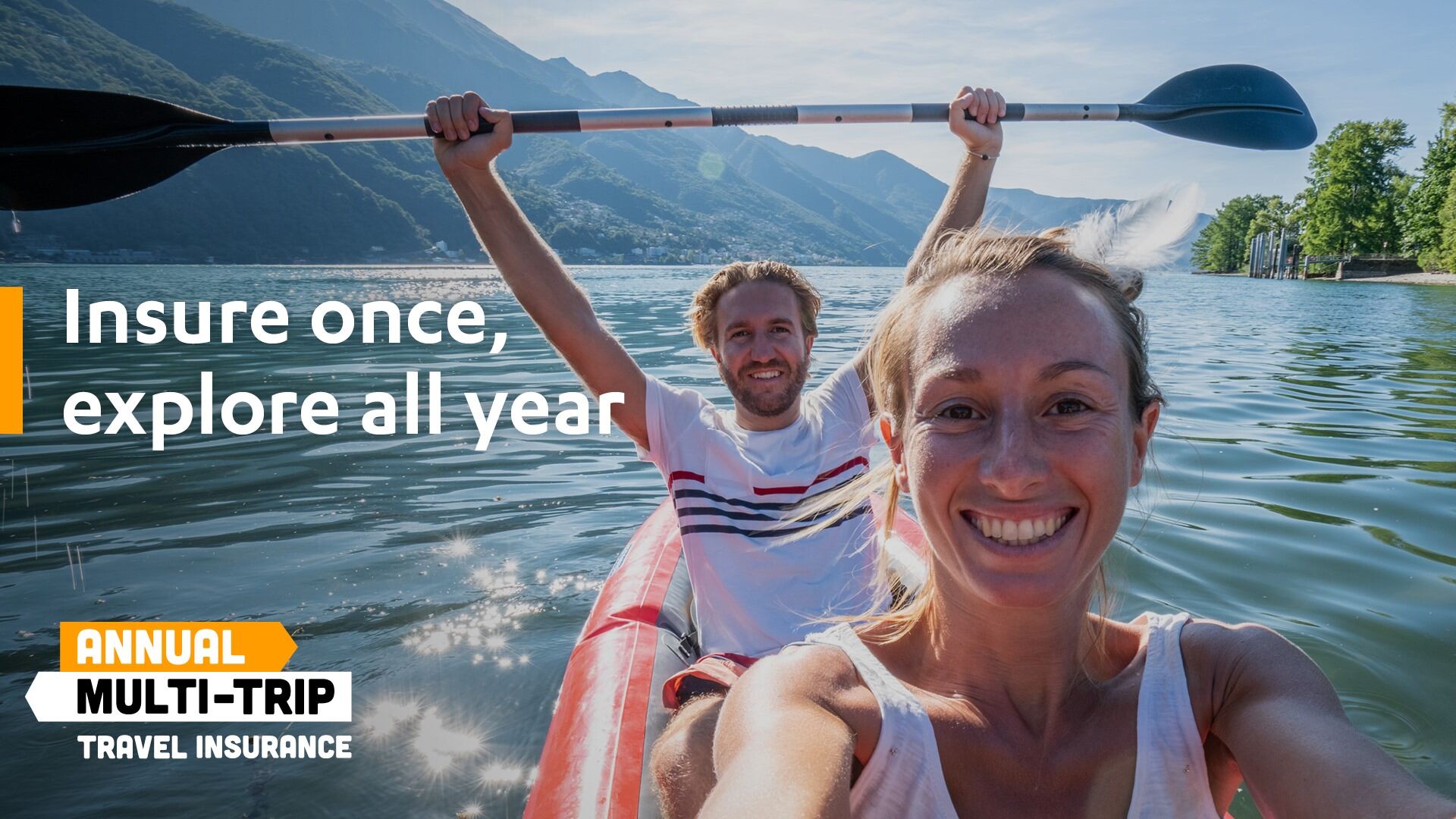 Young couple taking selfie portrait in red canoe on mountain lake