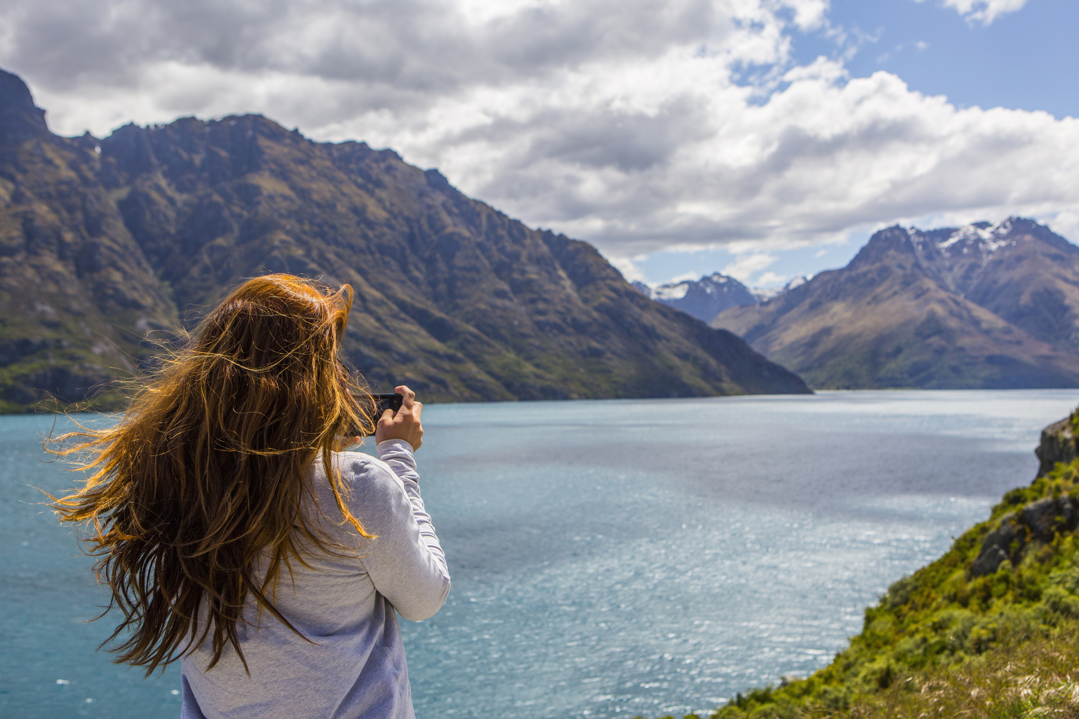 Woman taking photo of lake