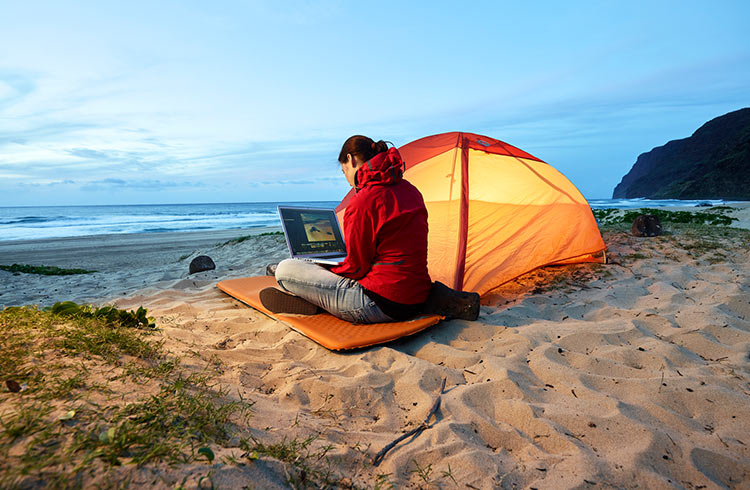 Woman on laptop at the beach