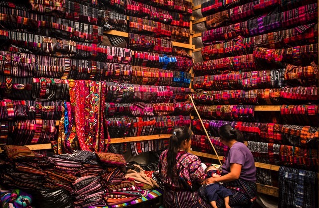 2 local women selling colorful fabric. Chichicastenango, Guatemala