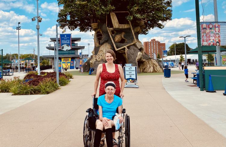 A young woman pushes her mother in a wheelchair in front of the Children's Museum in Indianapolis.