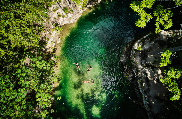 An aerial image of people swimming in a natural swimming hole