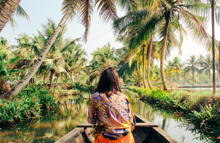 A woman traveler on a boat under palms