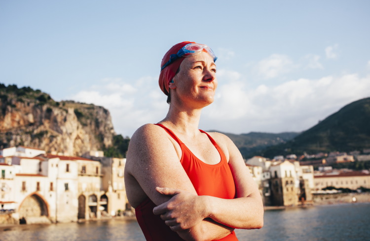 A woman swimmer smiles out at the sea off the coast of Sicily.