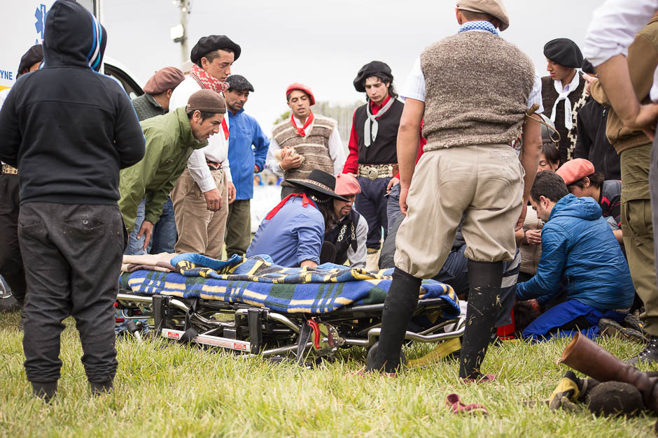 The riders risks their lives each time they mount a horse. This is an extreme sport with a high level of danger and every day there are serious injured, some had even died. In the picture: Group of gauchos around an injured rider. 