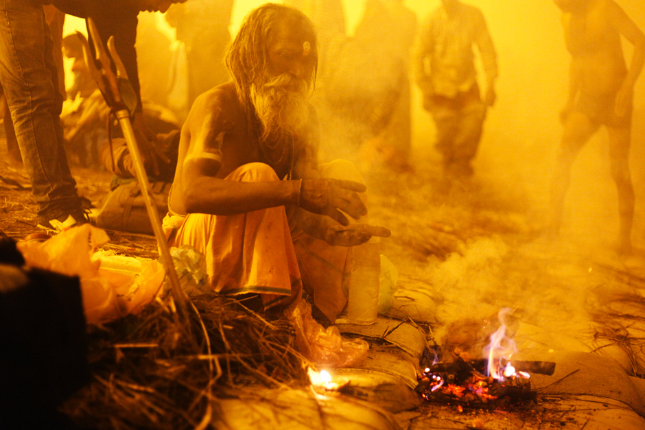 Rituals - It's 4 am in the morning. Nonetheless, the flow of pilgrims keep growing. This sadhus is doing a ritual in the middle of the fog. The public lightings shade a yellow light on the scenery. The dust and haze enhance the mystic atmosphere.  