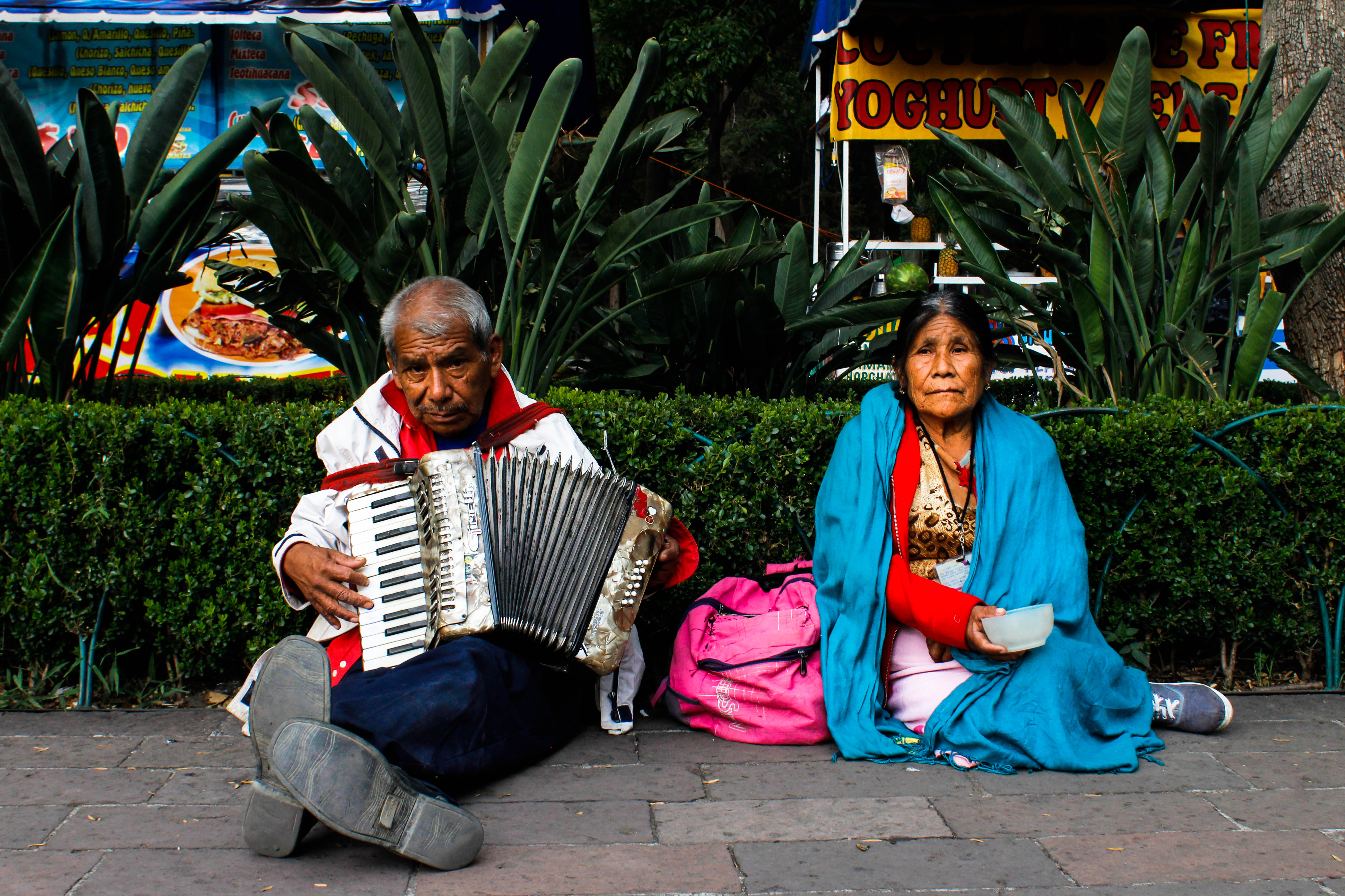 Outside the National Museum of Anthropology in Mexico City a man plays the accordion, while a woman asks for money.