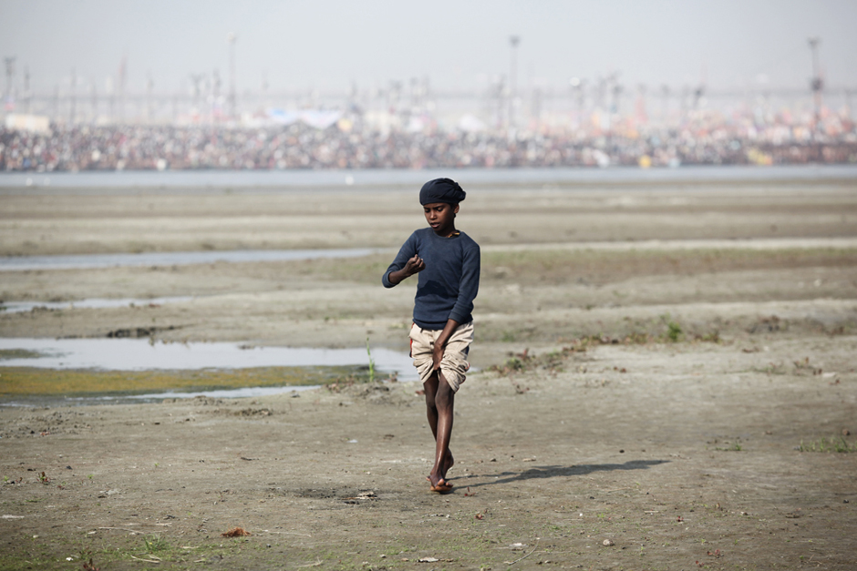 Take a break - A lonely kid walk on the opposite side of Sangam. In his back, the crowd is gathering at the border or the river. Between  Mauni Amavasya Snan and Paush Purnima the crowd will double every days.  