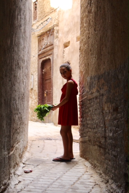 Tannery Girl: A young girl ran down an alley into my shot. At first she didnt want her photo taken, but she quickly changed her mind, posed, then blew me a kiss before disappearing into the medina. 