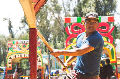 Xochimilco resident and boatman Isaac navigates through the waters of my 2-hour ride of the canal. He told me he is a student and makes his living this way.