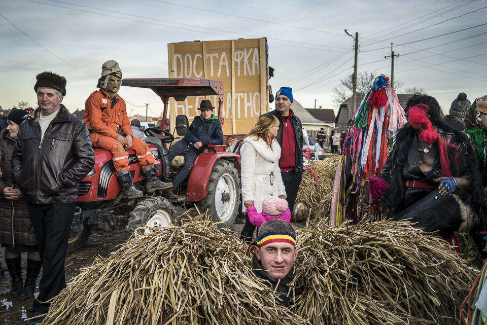 A group of dressed villagers and visitors rest during the festival Malanka in Krasnoilsk, Chernivtsi region, Ukraine