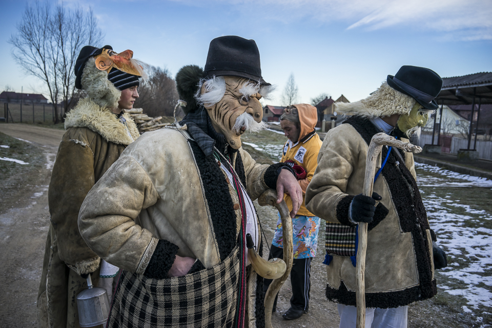 A group of villagers wearing costumes of older men are taking a pause from a long day of celebrating Malanka in Krasnoilsk, Chernivtsi region, Ukraine