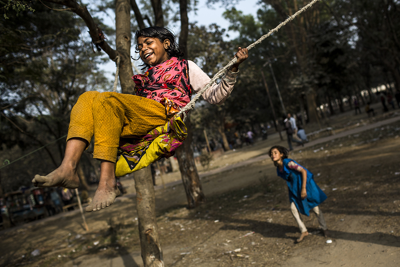 Two little girls who are living in a slum area situated at the heart of Dhaka, Bangladesh enjoy a ride on a makeshift swing. Dhaka has been named, according to several reports, the worst city in the world to live in.