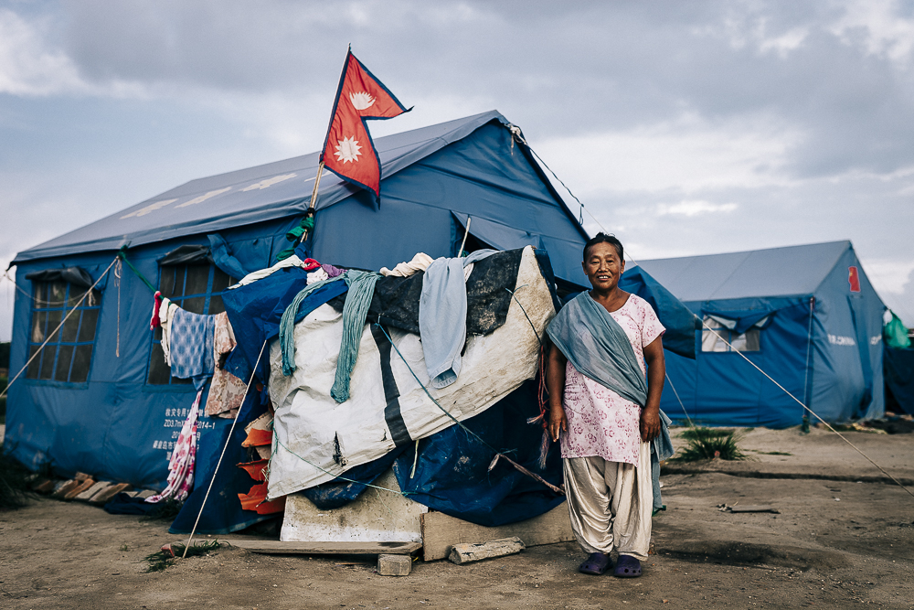 A Nepalese woman who have lost her home wanted her photograph taken with the national flag outside the makeshift tent she is living in.