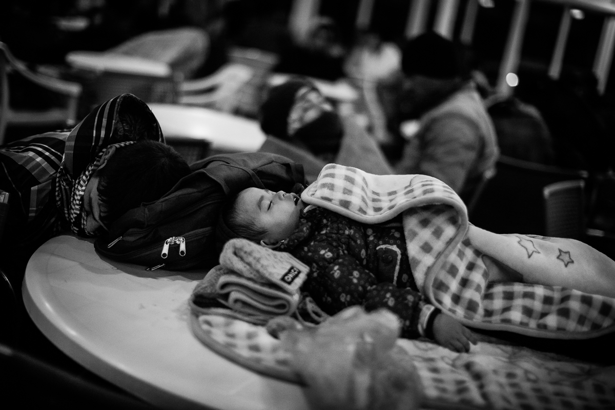 Sleeping on the ferry boat that brings the refugees from the island to Athens, this young kid is about to start the long European journey that will bring him to a new life in Western Europe.