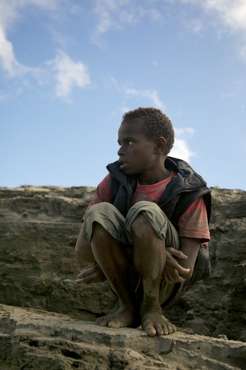 Eleven years old boy, working at big river boat. Dekai, West Papua