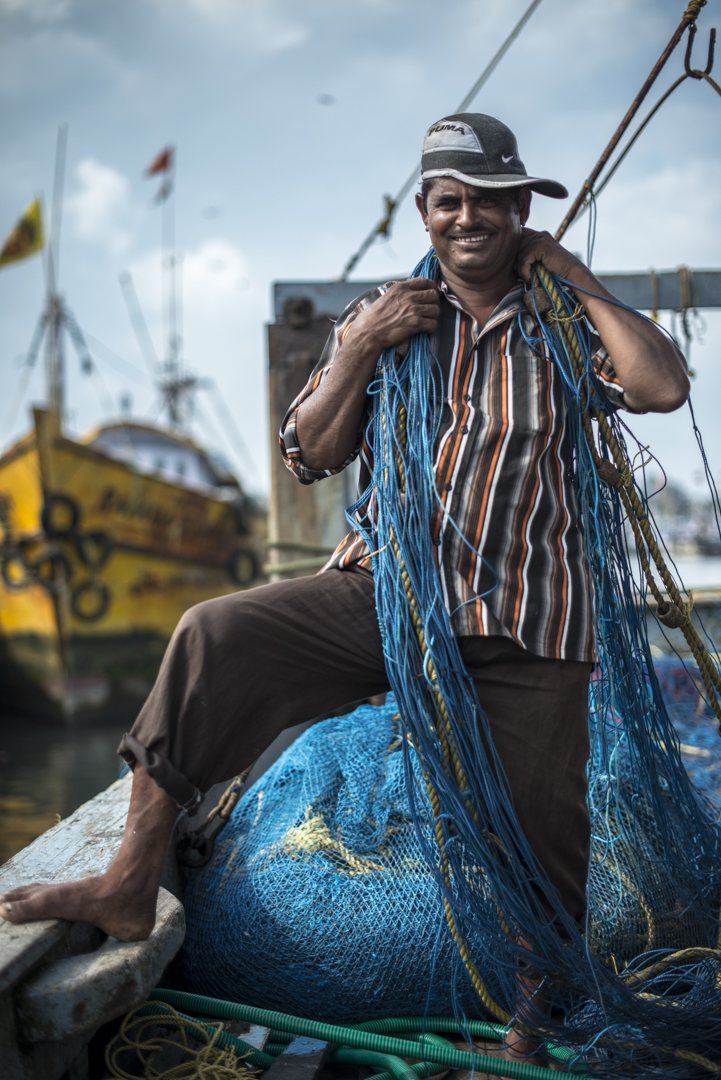 As the clouds were clearing I noticed Sendhil's crew member Murali looked very pleased to port after a long time spent at sea. He expressed how happy he was, to be meeting his family. He seemed fit and agile, well accustomed to wrapping up the fishing nets in bundles until they use them for their next stint at sea. He gladly posed for a shot.
