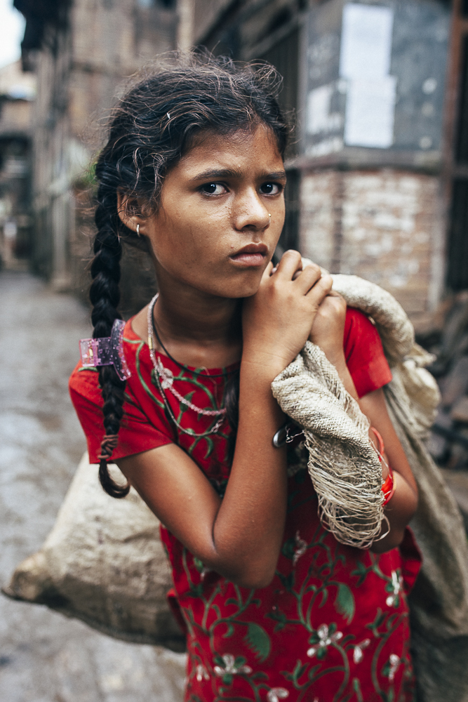 A young Nepalese girl selling off the rubbles from her home to make a small income to survive.