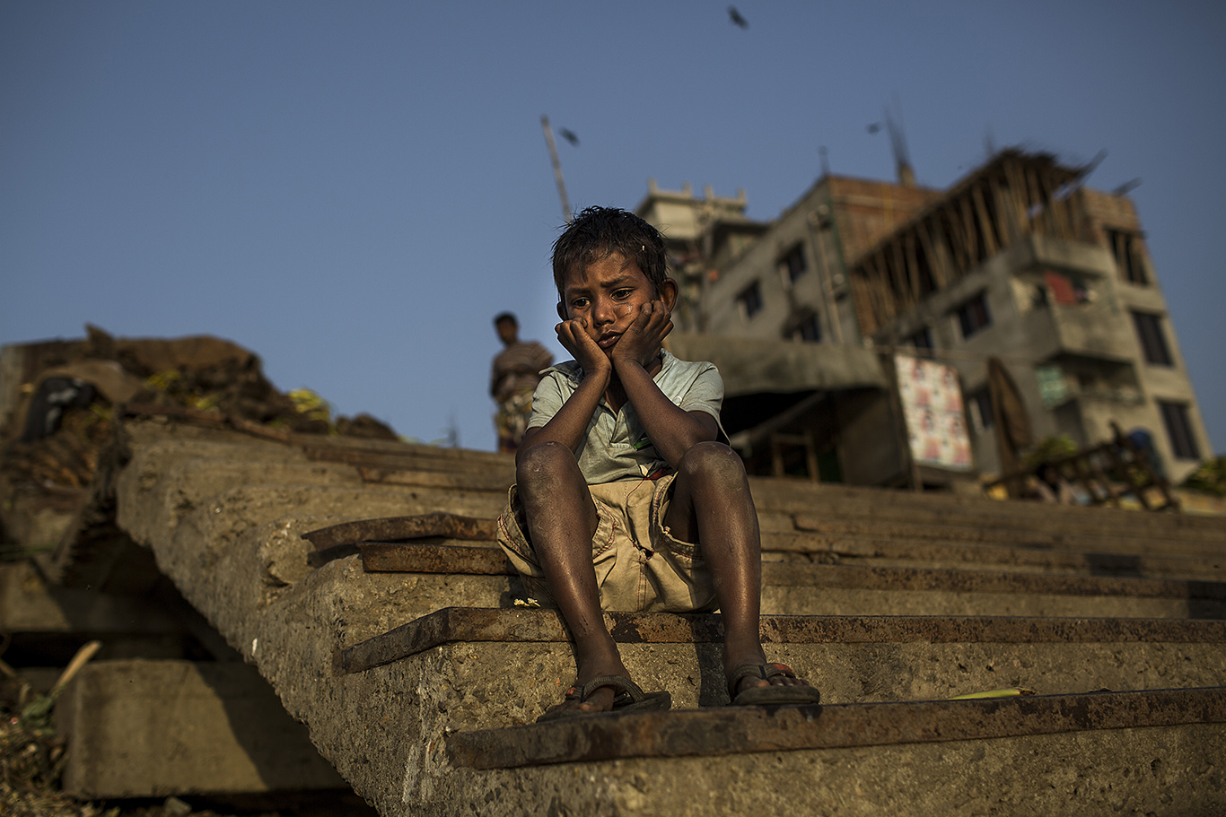 A thoughtful kid is seen on the banks of the Buriganga River -not pictured- in Dhaka, Bangladesh. He and his family work in the river recycling materials. The state of surface and ground water pollution in Bangladesh is alarming. Especially the Buriganga is largely polluted by Dhaka city. Dhaka has been named, according to several reports, the worst city in the world to live in.
