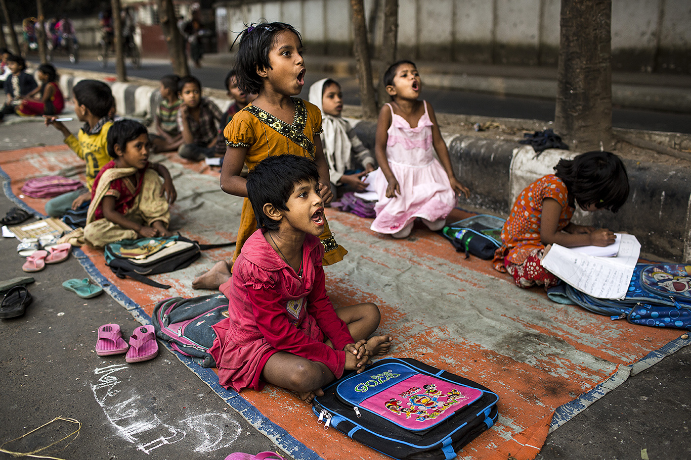 A group of children attend to a class at a makeshift street school in Shahbag area, situated at the heart of Dhaka. They are slum dwellers or orphans who receive classes several days per week by foundations and individuals helping in the education of street children. Dhaka has been named, according to several reports, the worst city in the world to live in.