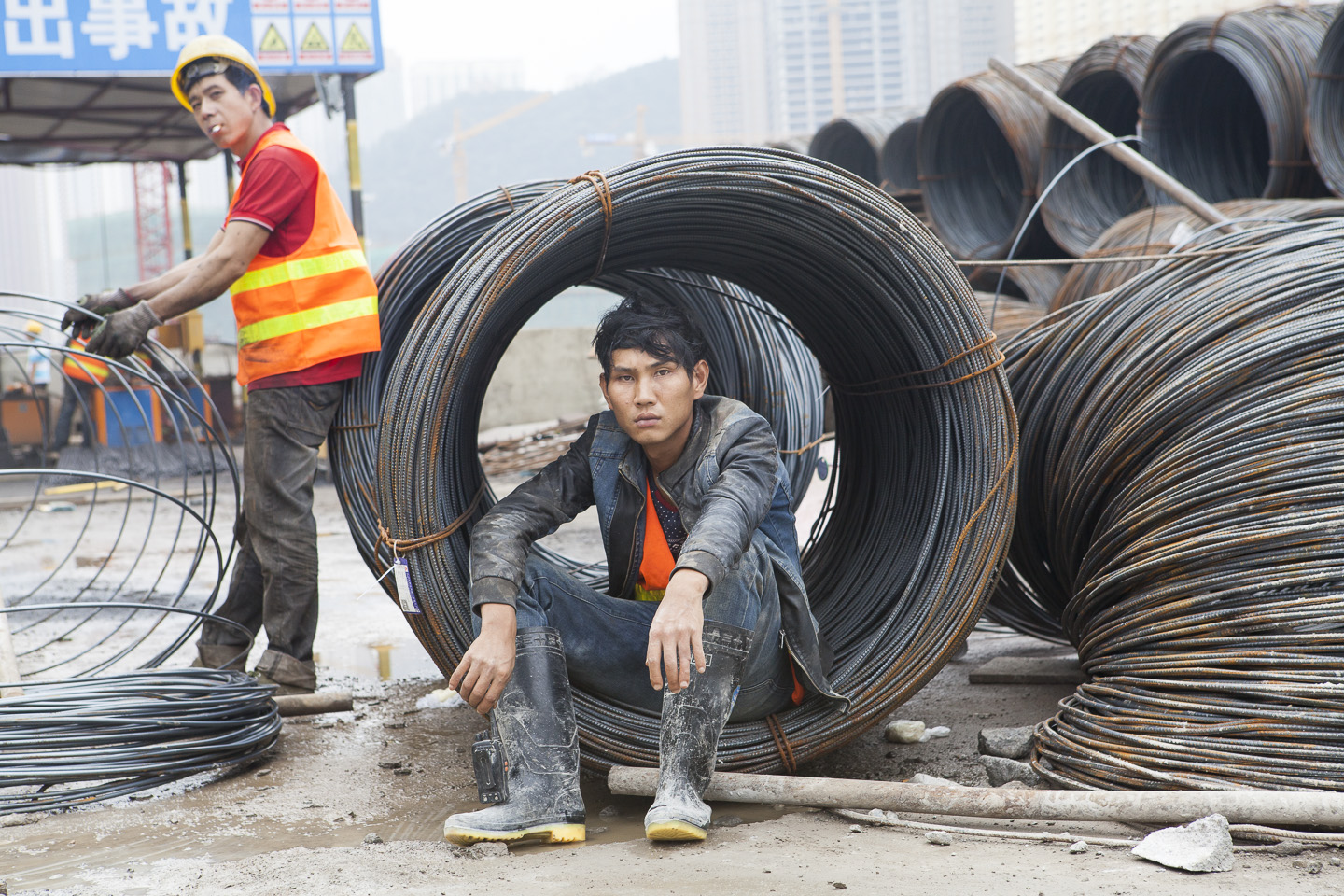 Many of the construction workers in China have migrated from rural areas to look for wealth in the cities that are being erected all round China. This migrant worker has just finished a long day shift and is taking a break before resting for the night.