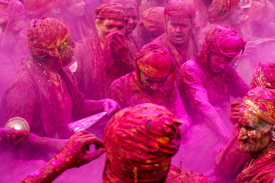 Men sangs songs of holi festival in temple courtyard at nandgoan despite the holi colours splashes all over them.