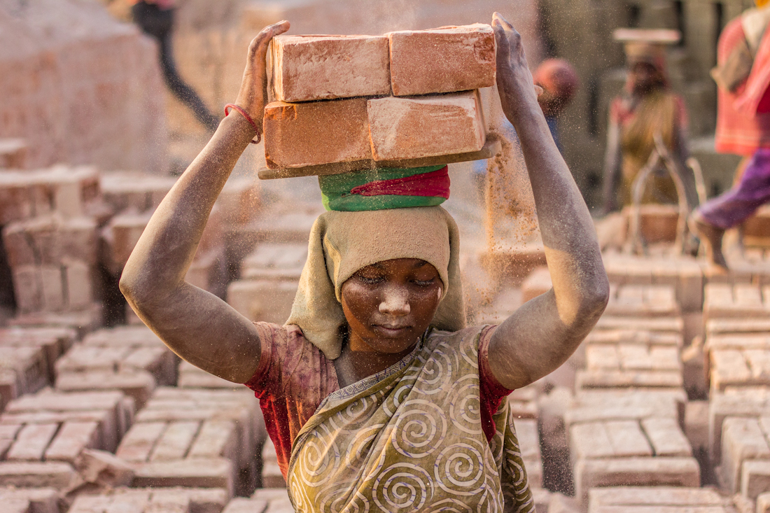 Portraiture of Nati, mother of three kids, carefully but confidently is preparing her brick load.
