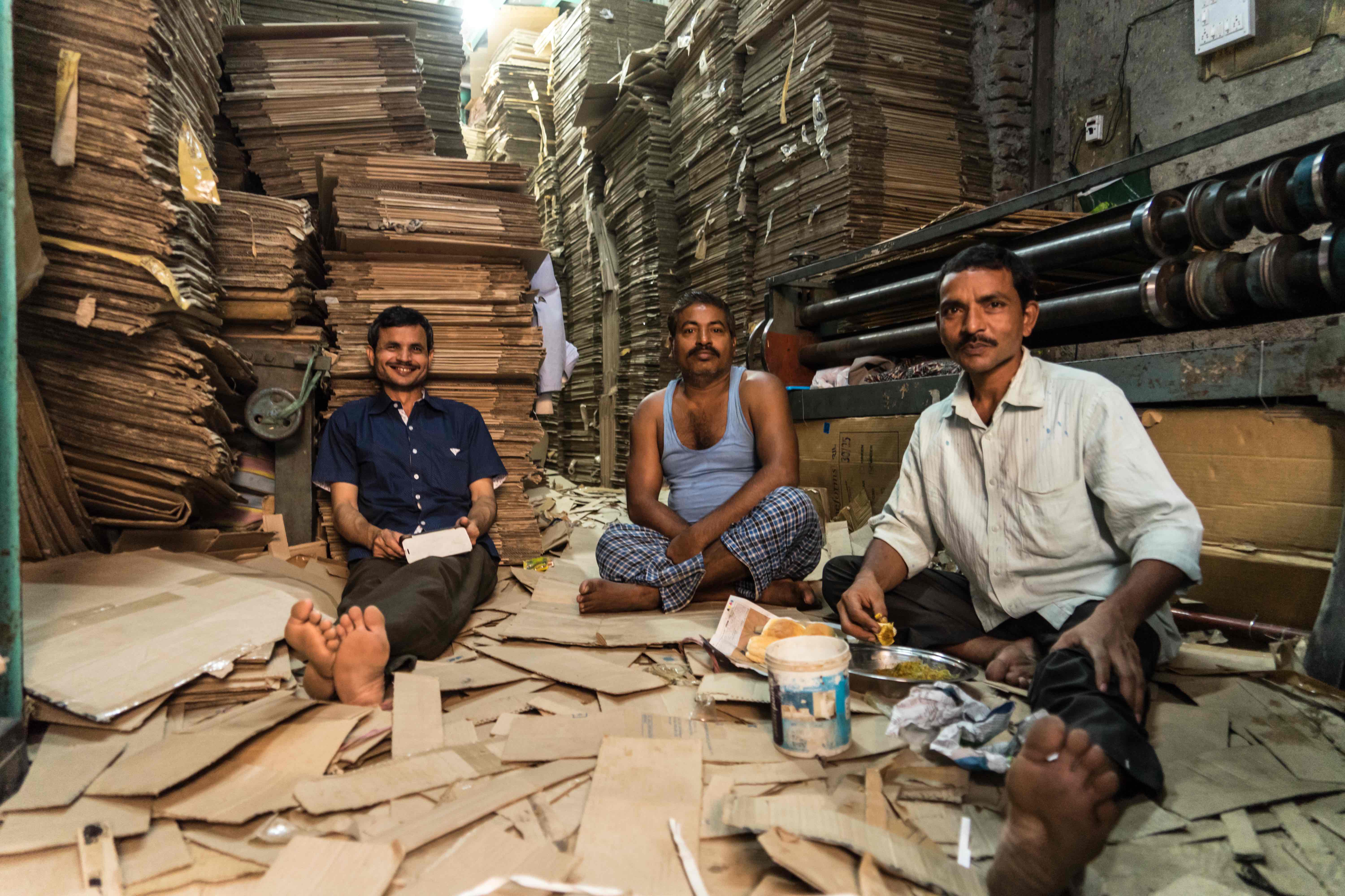 Lunch time in one of the small businesses that receives brown cardboard boxes from all parts of Mumbai