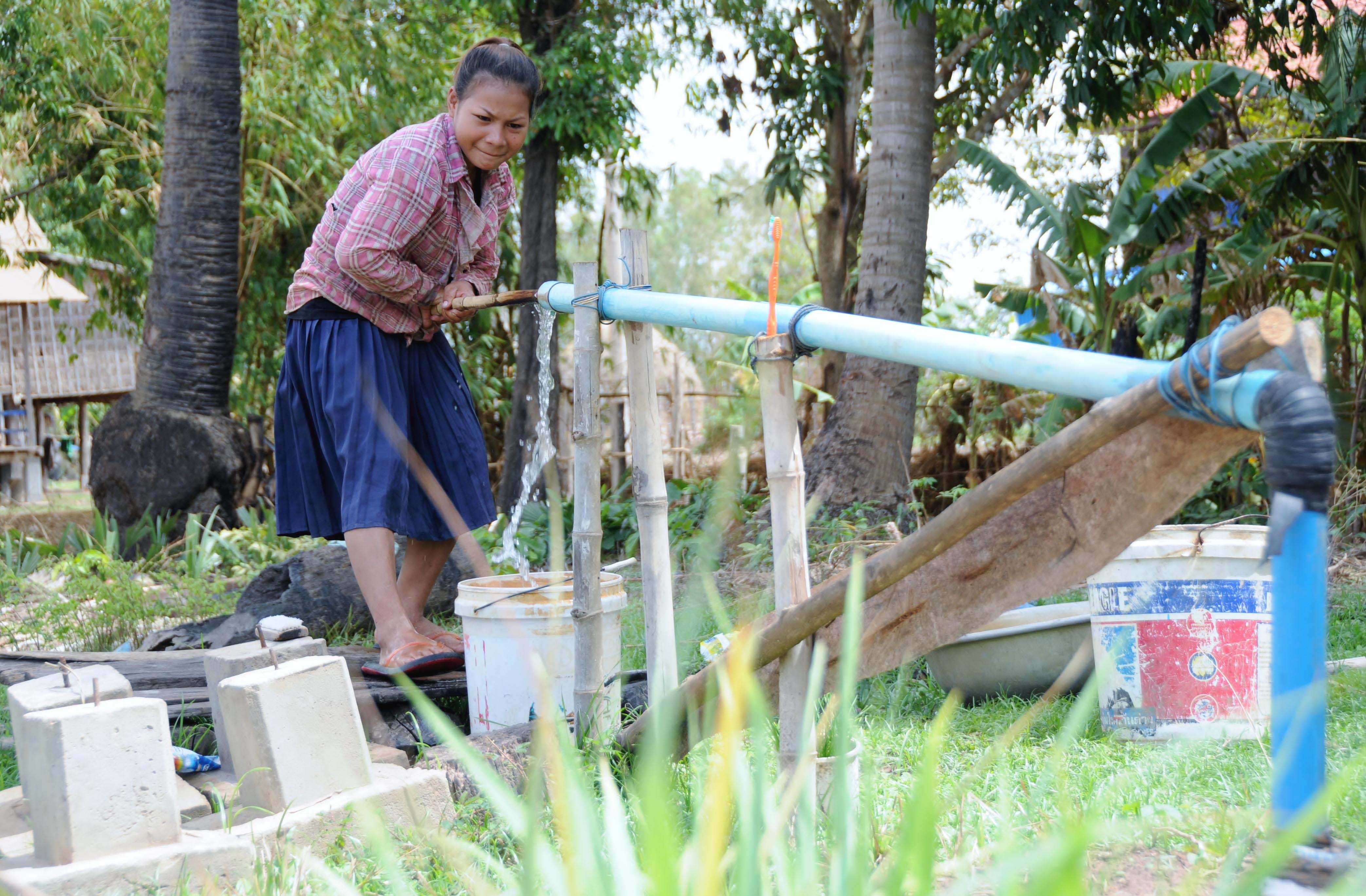 Nary, 15-year-old, pumps water for preparing lunch before she goes to work on a construction site, 30 km from Angkor Wat Temple in Siem Reap province in order to keep her younger brother at school.