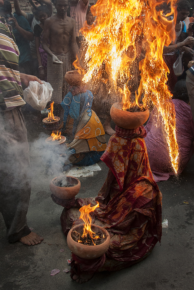 After offering the puja, Carrying clay pots filled with fire is also an integral part of this festival. It is believed that it will bring good fortune for the devotee & their family.